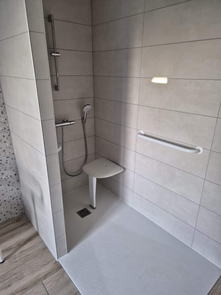 Salle de bain PMR avec douche de plain-pied et équipements adaptés pour plus de sécurité