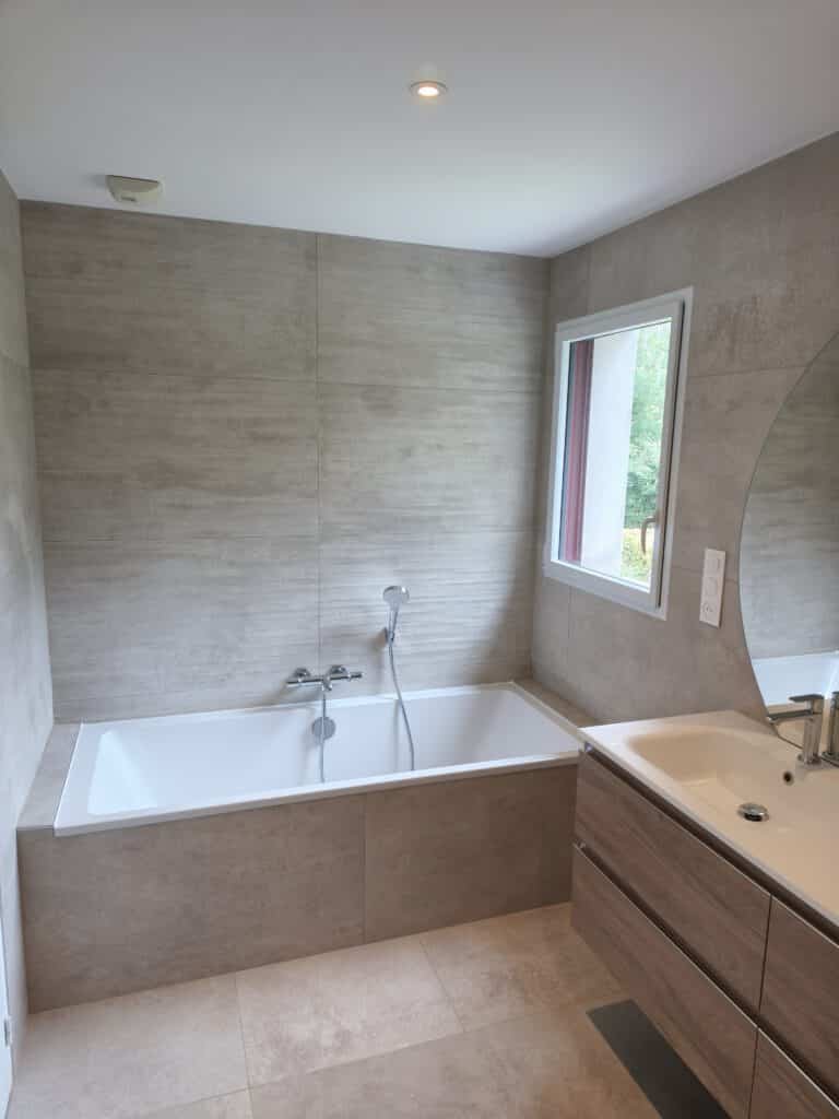 Salle de bain rénovée avec baignoire et aménagement moderne dédié au confort