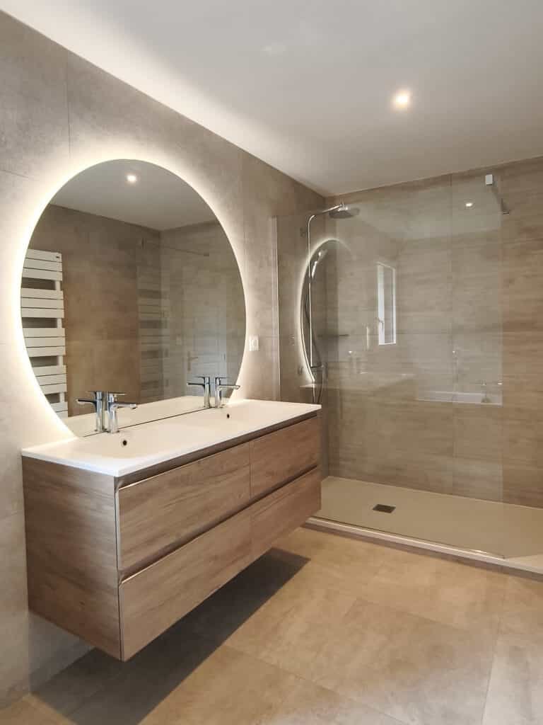 Salle de bain avec miroir rond lumineux et double vasque pour un espace pratique et élégant